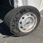 A tire is sitting on the side of a trailer.